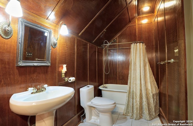 bathroom with toilet, tile patterned floors, wood walls, and lofted ceiling