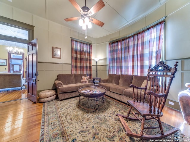 living room featuring light hardwood / wood-style flooring and ceiling fan with notable chandelier