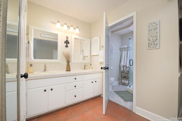 bathroom with decorative backsplash, vanity, toilet, tile patterned floors, and a textured ceiling