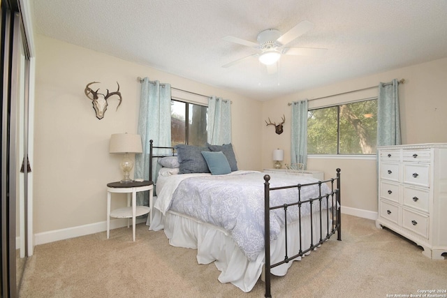 carpeted bedroom featuring a textured ceiling and ceiling fan