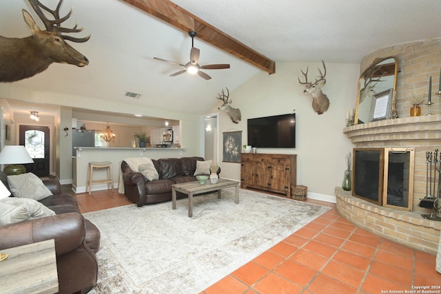 tiled living room featuring vaulted ceiling with beams, a fireplace, and ceiling fan