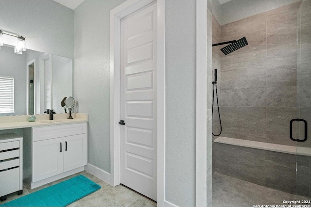 bathroom featuring tile patterned flooring, vanity, and walk in shower