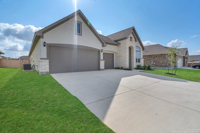 view of front facade featuring a garage, central AC unit, and a front lawn