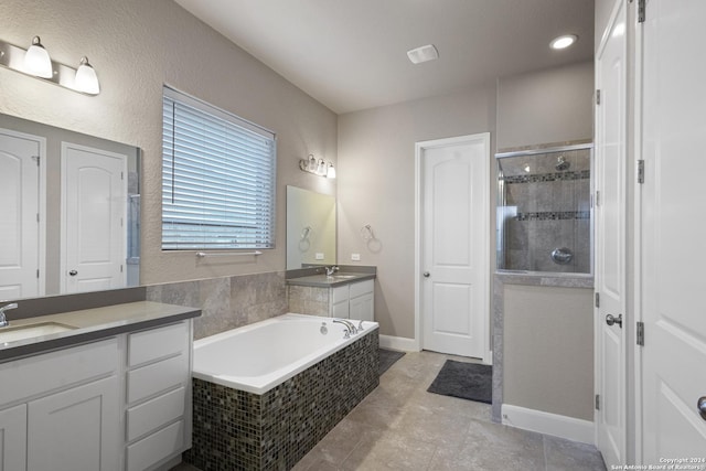 bathroom with plus walk in shower, vanity, and tile patterned floors