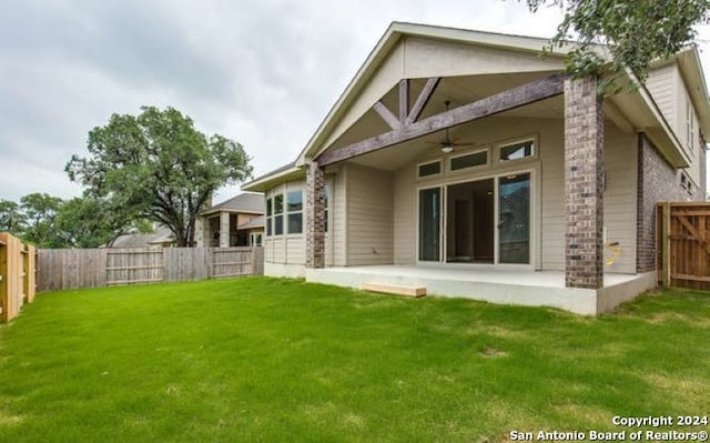 rear view of house with a yard, a patio area, a fenced backyard, and a ceiling fan