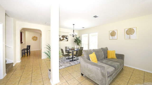 tiled living room with a chandelier