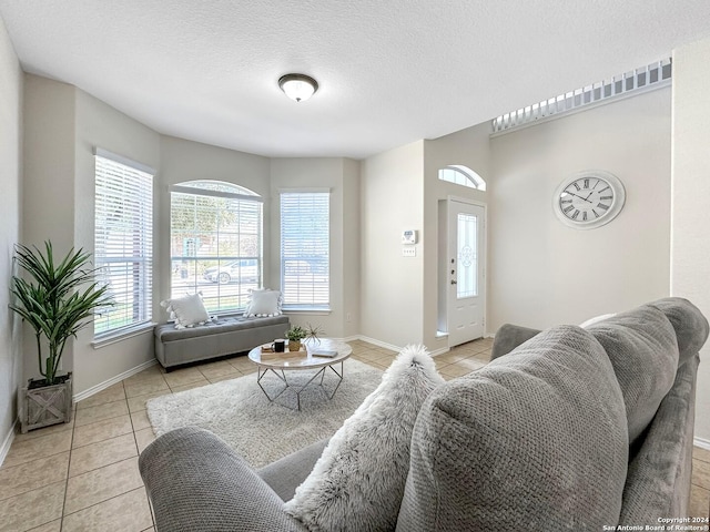 tiled living room with a textured ceiling and plenty of natural light