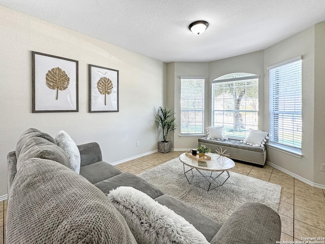 tiled living room featuring a textured ceiling