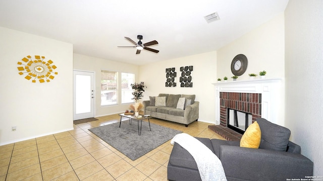 living room with a fireplace, light tile patterned floors, and ceiling fan