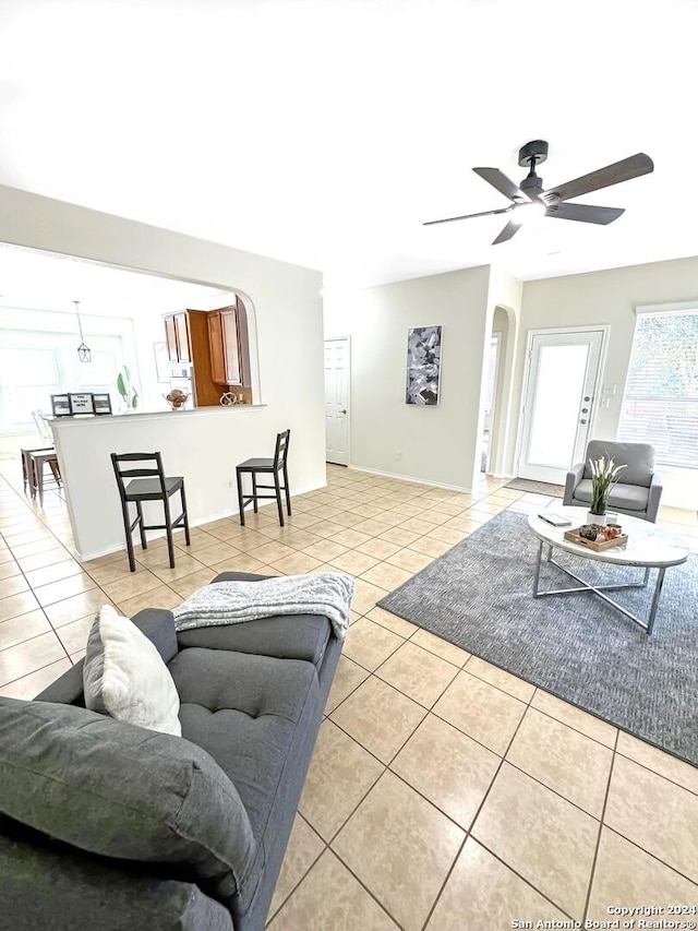 tiled living room with ceiling fan