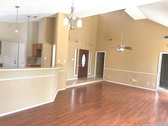 foyer entrance featuring ceiling fan with notable chandelier, a textured ceiling, high vaulted ceiling, and hardwood / wood-style floors