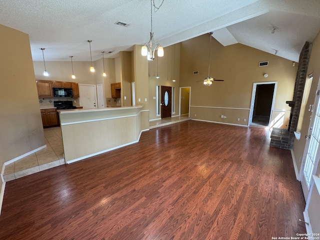 kitchen featuring ceiling fan with notable chandelier, a textured ceiling, decorative light fixtures, black appliances, and hardwood / wood-style flooring