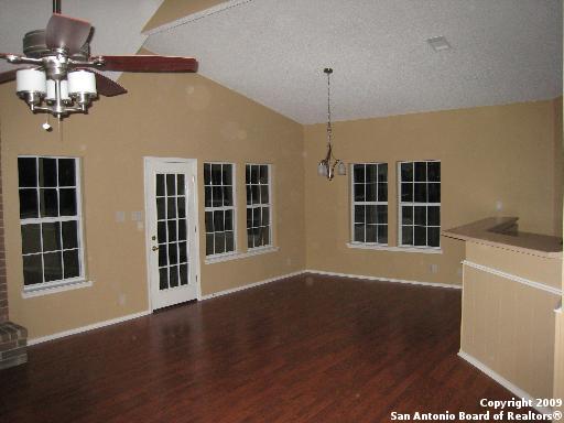 unfurnished dining area featuring vaulted ceiling, a textured ceiling, ceiling fan, and dark hardwood / wood-style floors