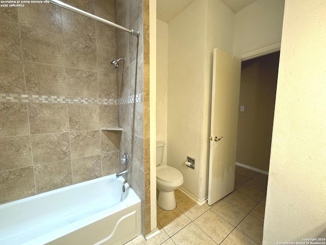 bathroom with tile patterned flooring, toilet, and tiled shower / bath combo