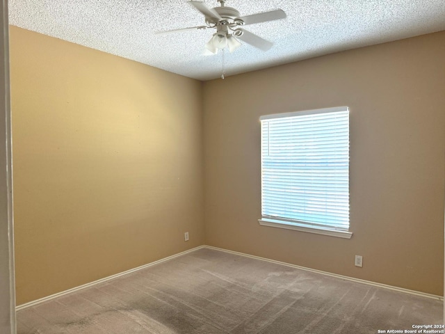 carpeted empty room featuring a textured ceiling and ceiling fan