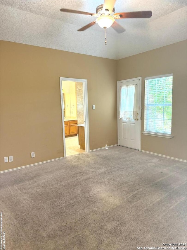 carpeted empty room with a textured ceiling and ceiling fan