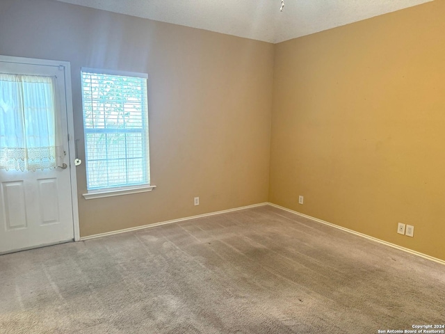 carpeted empty room featuring a textured ceiling