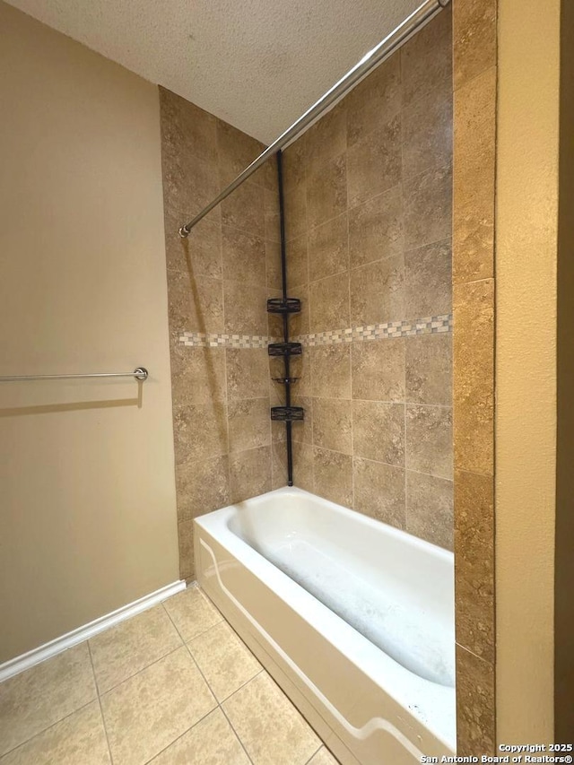 bathroom with tiled shower / bath combo, tile patterned floors, and a textured ceiling