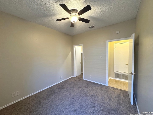 unfurnished bedroom with ceiling fan, carpet, and a textured ceiling