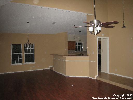 interior space with a textured ceiling, ceiling fan, hardwood / wood-style floors, and high vaulted ceiling