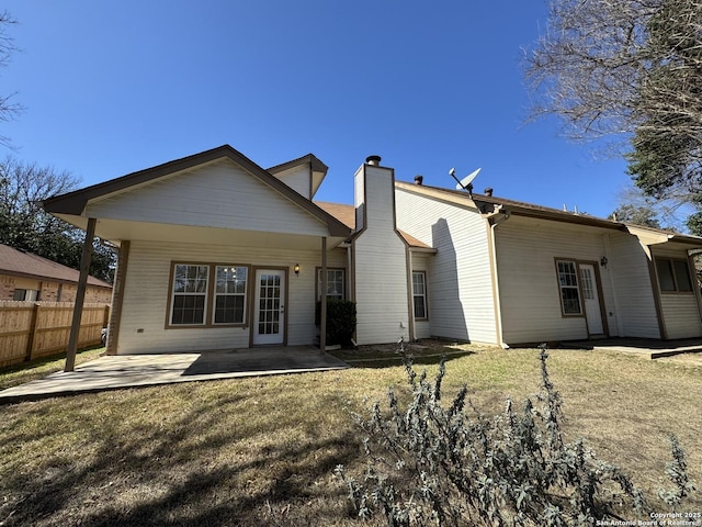 rear view of property featuring a yard and a patio area