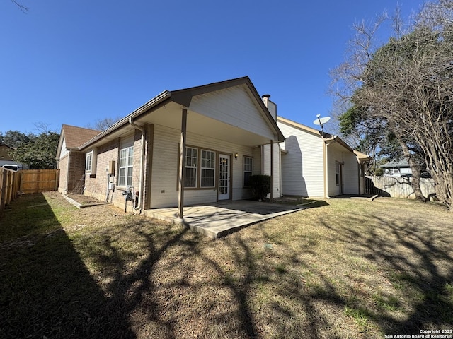 rear view of property featuring a patio and a yard