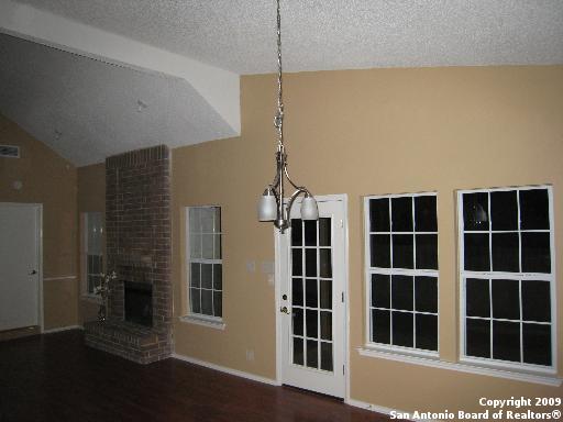 interior space with hardwood / wood-style flooring, a textured ceiling, a brick fireplace, and lofted ceiling