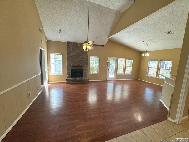 unfurnished living room with ceiling fan, wood-type flooring, a fireplace, and lofted ceiling