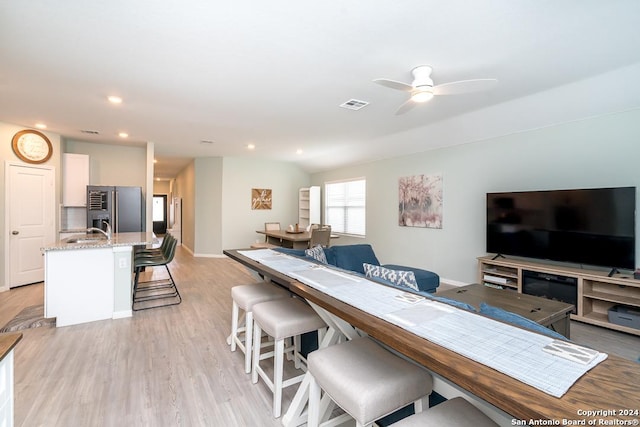 living room featuring ceiling fan, recessed lighting, visible vents, vaulted ceiling, and light wood-type flooring