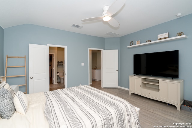 bedroom with ceiling fan, connected bathroom, light hardwood / wood-style flooring, and lofted ceiling