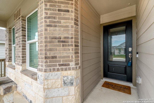 doorway to property featuring brick siding