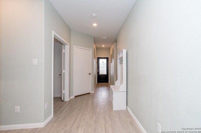 walk in closet with light hardwood / wood-style floors