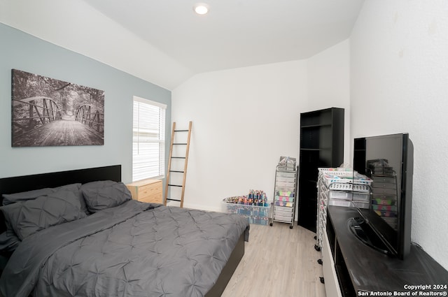 bedroom featuring light hardwood / wood-style flooring and lofted ceiling