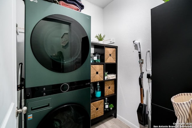 laundry room featuring stacked washer and dryer, laundry area, and wood finished floors