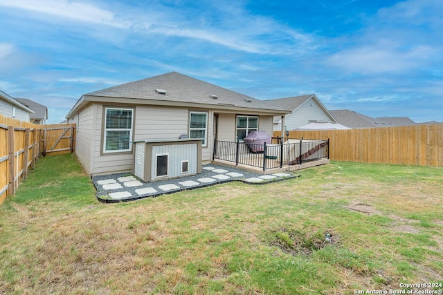 rear view of property featuring a patio, a lawn, and a fenced backyard