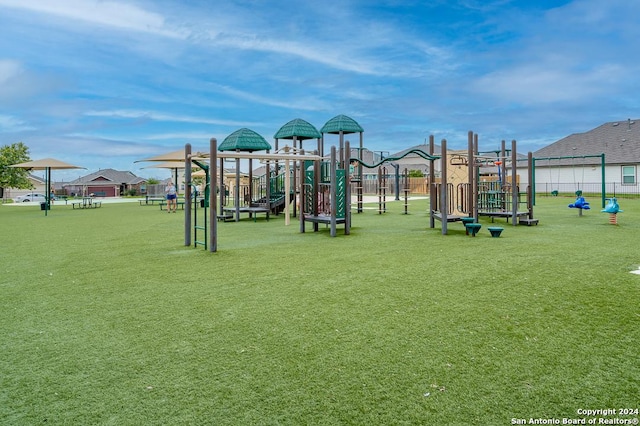 community jungle gym with a yard and fence