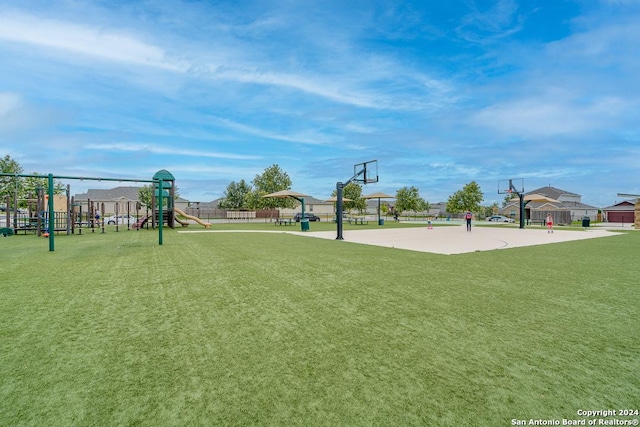 exterior space with community basketball court, a lawn, fence, and playground community