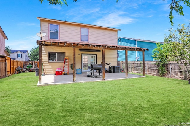 rear view of house featuring a lawn, cooling unit, and a patio area