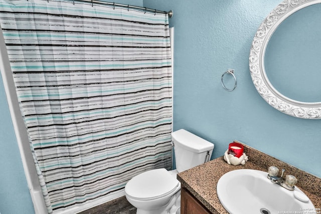 bathroom with toilet, vanity, and curtained shower