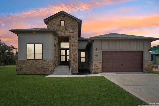 view of front of house with a garage and a yard