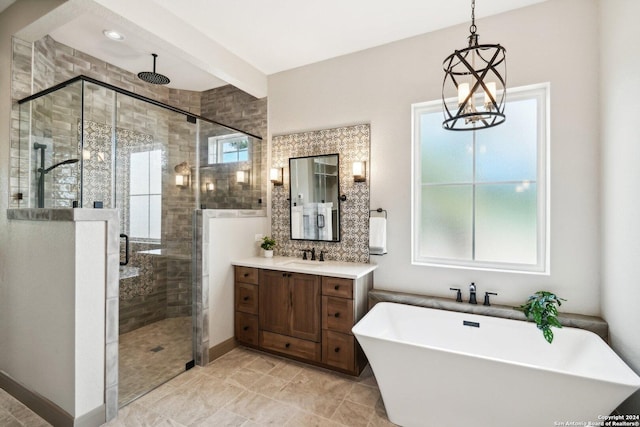 bathroom featuring vanity, shower with separate bathtub, and a notable chandelier