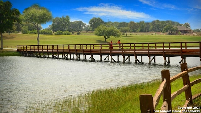 dock area with a water view and a yard