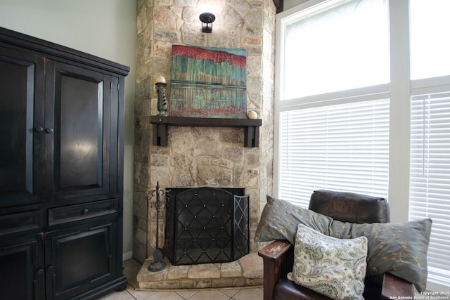 sitting room with a fireplace, light tile patterned floors, and plenty of natural light