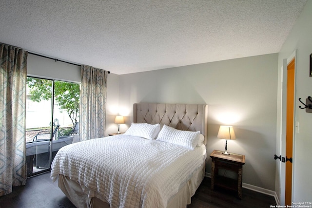 bedroom with dark hardwood / wood-style flooring and a textured ceiling