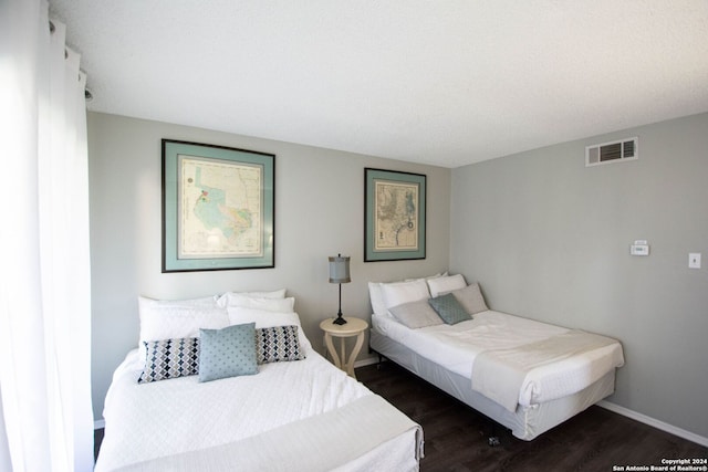 bedroom with dark wood-type flooring