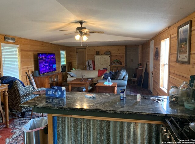 kitchen featuring wood walls, cooktop, and lofted ceiling