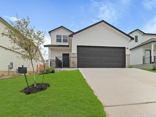 view of front of home featuring a garage, a front yard, and central AC unit