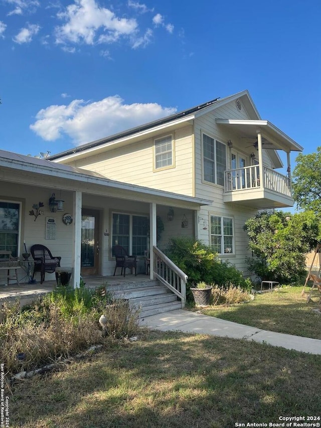 view of front of house with a balcony and a front lawn