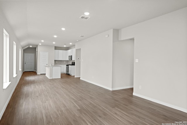 unfurnished living room with sink and hardwood / wood-style floors