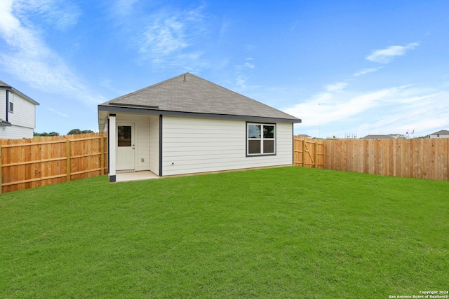 back of house featuring a lawn